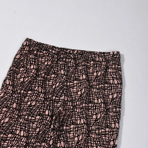 Detail of the elastic waistband on high-waist leggings with pink and black grid pattern