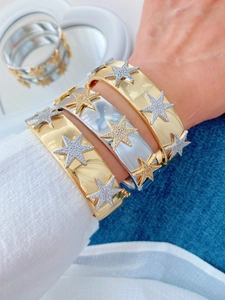 Close-up of gold and silver plated bangles with pave-set zircon star pattern detail