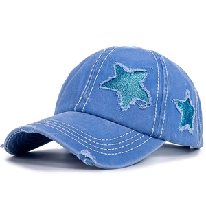 Dettaglio cappello baseball in cotone lavato blu con stella di paillettes e strappi