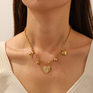 Collier en acier inoxydable doré avec pendentifs en forme de cœur porté par un mannequin