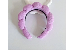 Detail of purple twisted sponge headband with non-slip black inner teeth on white background
