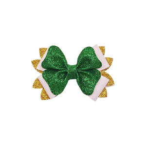 Macro shot of St. Patrick's Day hair bow with layered green and gold glitter texture