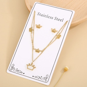 Detailed macro view of gold crown stainless steel necklace and earrings set on white card