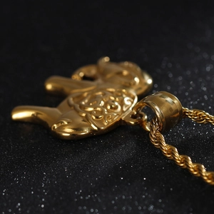 Gros plan du pendentif éléphant doré avec chaîne de corde sur un fond noir élégant