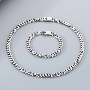Flat lay of 8mm silver stainless steel Cuban link chain necklace and bracelet set