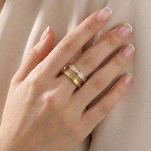 Detailed view of triple-layered gold ring with Roman numerals and twisted cable band