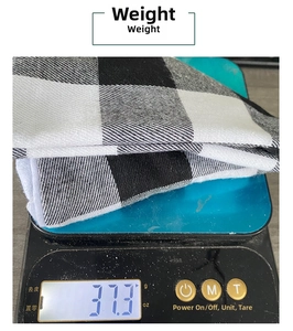 Detail showing the 37.3g weight of buffalo plaid Christmas tree skirt on a digital scale