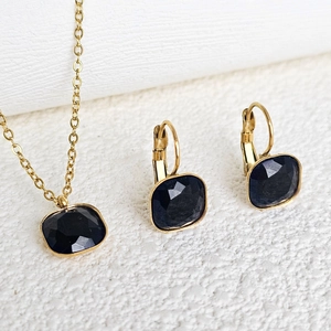 Macro view of gold stainless steel jewelry set featuring square black zircon stones