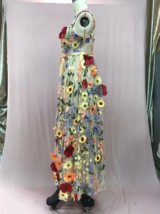 Détail de la broderie florale 3D colorée et du tissu en maille sur une robe de soirée chic