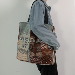 Detail of high-density jacquard tote bag with stylized cat patterns and wide straps