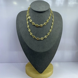 Detailed macro view of golden coffee bean link chain on a premium velvet jewelry display