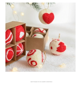 Detail view of handmade wool felt Christmas balls with heart patterns in gift box