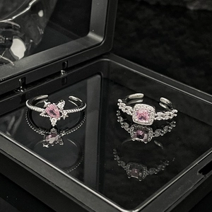 Detailed macro view of silver rings featuring pink gemstones and leaf-shaped crystal accents