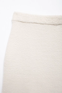 Detailaufnahme des elastischen Bunds und der Textur des cremefarbenen Strickrocks
