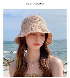 Detail of hand-crocheted beige straw sun hat with wavy brim and hollow texture