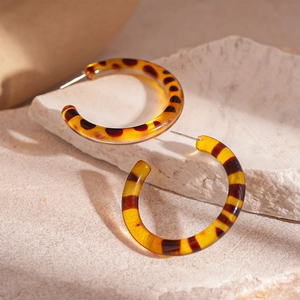 Close-up of C-shaped resin earrings with classic leopard print and tortoiseshell texture