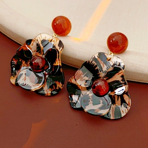Detail of tortoiseshell resin flower earrings with layered petals and vintage finish