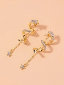 Gros plan de boucles d'oreilles spirales dorées avec strass et pompons étoiles
