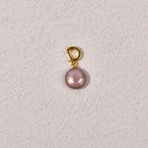 Detail view of a purple freshwater pearl pendant with a polished gold clasp