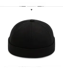 Front view of a minimalist black cotton docker hat featuring a vintage brimless design