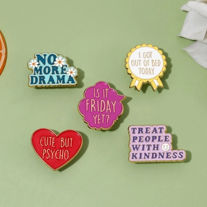 Five colorful enamel pins with English slogans on a light green background with decor