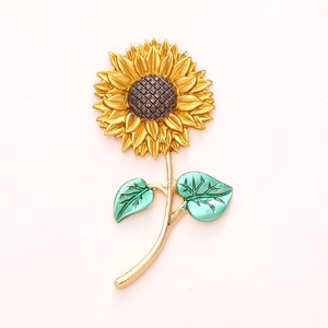 Top view of sunflower DIY alloy accessory with golden petals and green leaves