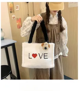 Detailed view of white fleece tote bag with LOVE embroidery and cute puppy charm accessory