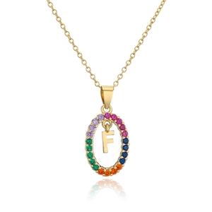 Macro shot of gold necklace pendant with rainbow cubic zirconia and capital letter F
