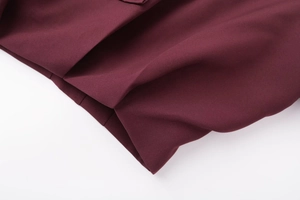 Detailed close-up of premium burgundy bomber jacket fabric with smooth woven texture