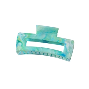 Detailed close-up of a large marbled green and blue hair claw clip with acetate finish