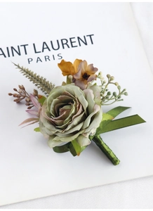 Close-up of handmade green silk rose boutonniere with colorful berries and green ribbon