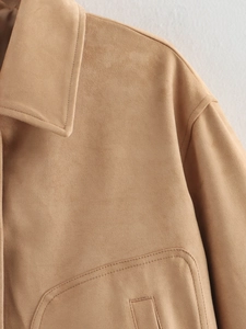 Close-up of camel suede jacket showing neckline stitching and large pocket details