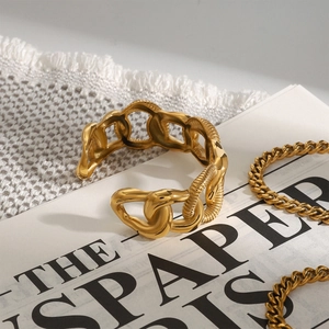 Detail of gold chunky chain bangle with alternating smooth and twisted textured links