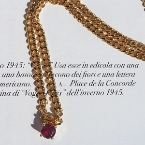 Detailed macro view of 18k gold plated Cuban chain necklace featuring a red zircon gemstone
