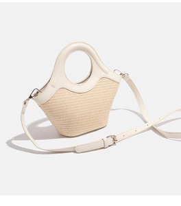 Detail showing woven texture and circular handle of beige crossbody handbag
