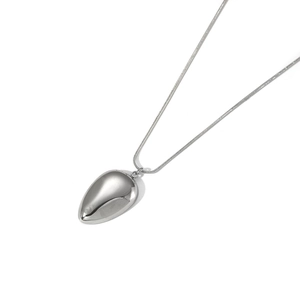 Close-up of a silver water drop pendant with a polished snake bone chain on white background