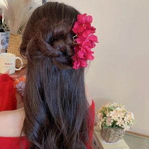 Elegant deep red fabric flower hair claw clip worn by model for high-end styling
