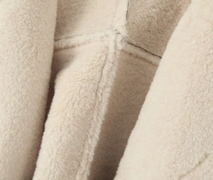 Gros plan sur la texture du tissu polaire beige et les détails des coutures