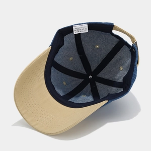Internal view of bicolor denim cotton baseball cap with 100% cotton label and stitching