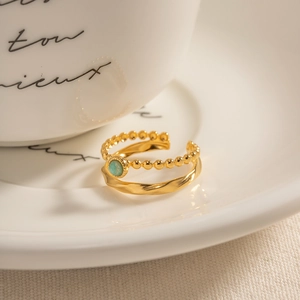 French vintage style adjustable gold ring with turquoise stone inlay on a coffee cup