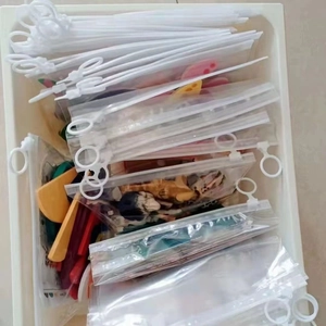 Detailed top view of transparent plastic zipper bags organizing small toys in a drawer