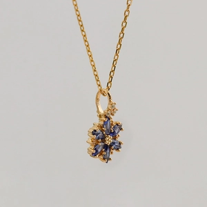 Vue macro du poinçon S925 sur le pendentif fleur vintage en argent doré et tanzanite