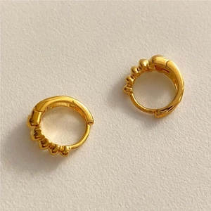 Detailed close-up showing the S925 hallmark on a pair of minimalist gold twisted earrings