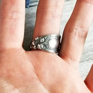 Close-up of vintage silver floral embossed ring with antique finish on female hand