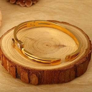 Elegant 18K gold-plated stainless steel bangle with two square zircon stones on wood