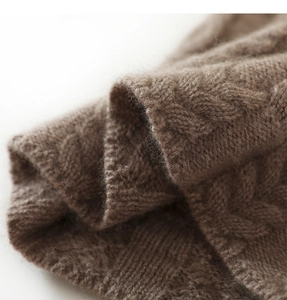 Macro detail of dark brown cashmere knit fabric with soft texture and cable stitch pattern