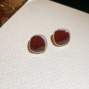 Macro shot of vintage red zircon stud earrings with gold plating and sparkling gemstones