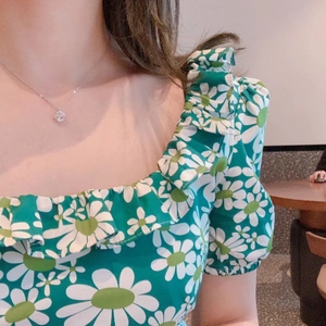 Floral print top with ruffle neckline and bubble sleeves paired with a silver necklace