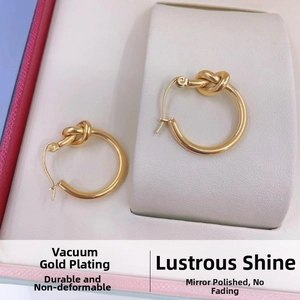 Macro detail of 18K gold knot hoop earrings featuring high polished mirror finish texture