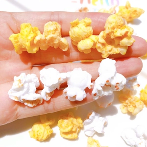 Handheld view of miniature resin popcorn accessories for DIY crafts and jewelry making
